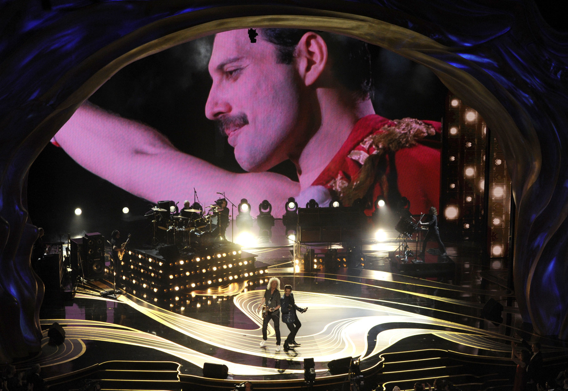 An image of Freddie Mercury appears on screen as Brian May, left, and Adam Lambert of Queen perform at the Oscars on Sunday, Feb. 24, 2019, at the Dolby Theatre in Los Angeles. (Photo by Chris Pizzello/Invision/AP)