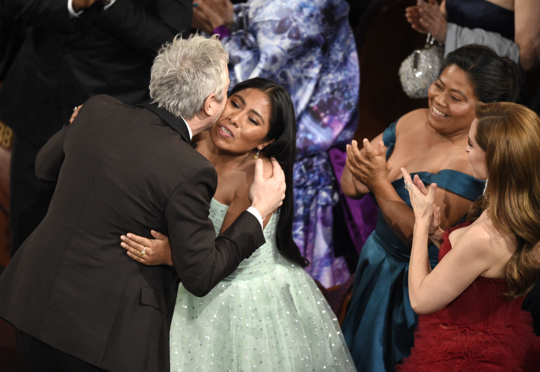 Yalitza Aparicio, right, congratulates Alfonso Cuaron in the audience as he is announced the winner of the award for best cinematography for "Roma" at the Oscars on Sunday, Feb. 24, 2019, at the Dolby Theatre in Los Angeles. (Photo by Chris Pizzello/Invision/AP)