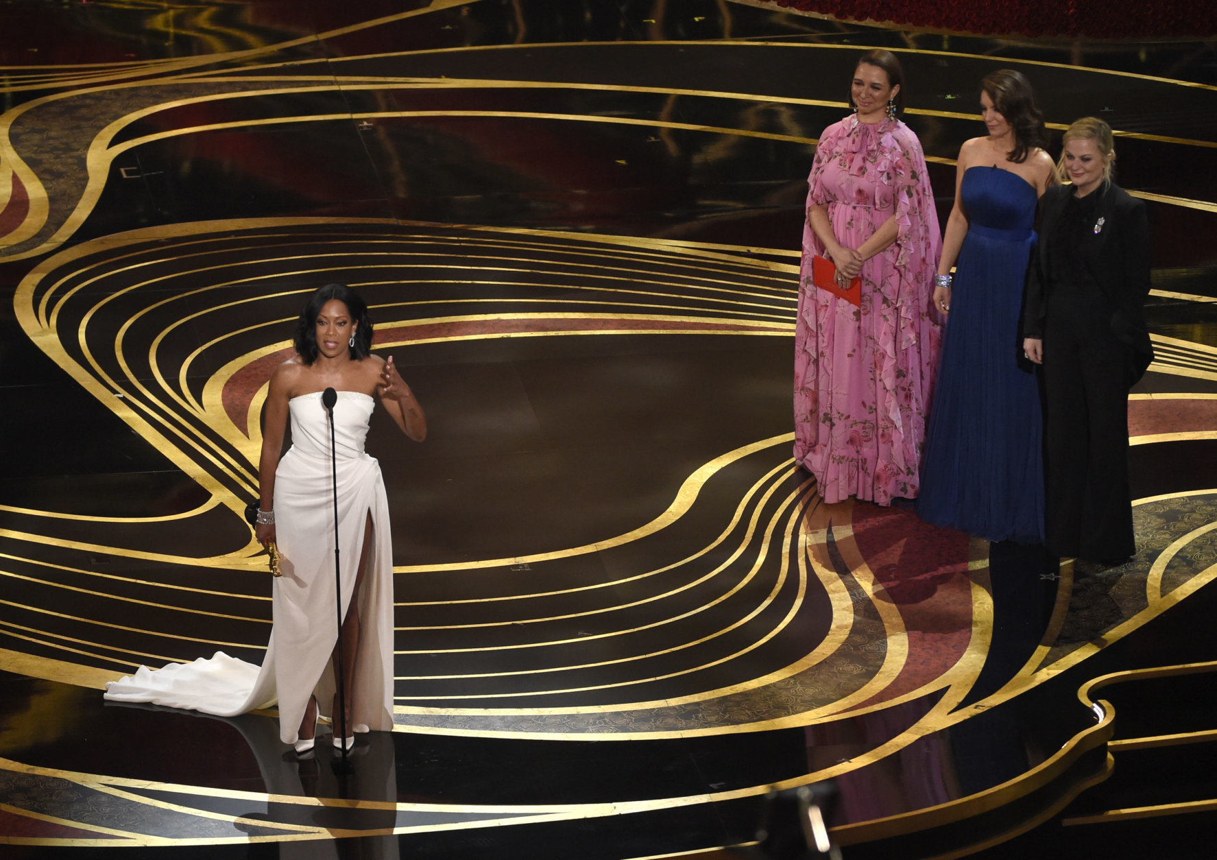Regina King accepts the award for best performance by an actress in a supporting role for "If Beale Street Could Talk," as Maya Rudolph, from second left, Tina Fey and Amy Poehler look on at the Oscars on Sunday, Feb. 24, 2019, at the Dolby Theatre in Los Angeles. (Photo by Chris Pizzello/Invision/AP)