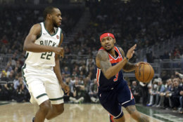 Washington Wizards' Bradley Beal, right, drives to the basket against Milwaukee Bucks' Khris Middleton during the first half of an NBA basketball game Wednesday, Feb. 6, 2019, in Milwaukee. (AP Photo/Aaron Gash)