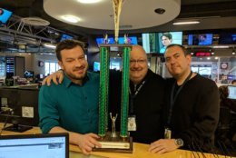 From left: Jason Fraley, news director Mike McMearty and sports anchor George Wallace share one last moment with the 2008 news-vs.-sales softball trophy. News won it so many times that it's a sore subject in the sales department. (WTOP/Jack Pointer)