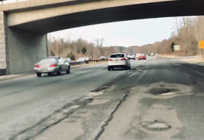 Tires slam up and down as you navigate around huge potholes, and you need to slow down significantly to avoid damaging your vehicle. (WTOP/Nick Iannelli)