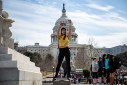 A protester holds her fist up, welcoming hundreds of students to the rally site on the Capitol building's west lawn. Here, protesters heard from both activists and members of Congress whose constituents have been directly impacted by shootings like Sandy Hook. (WTOP/Alejandro Alvarez)