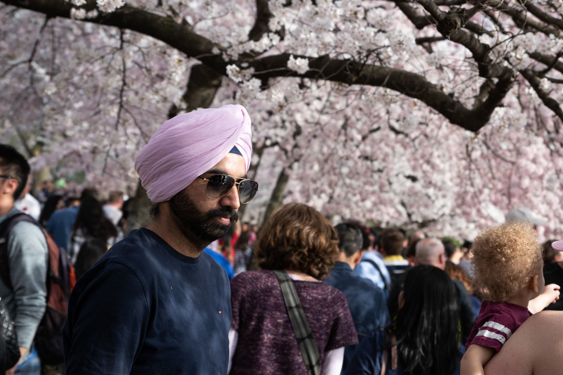 A visitor to the cherry blossom festival is seen on March 30, two days before the peak bloom forecast by the National Park Service. (WTOP/Alejandro Alvarez)