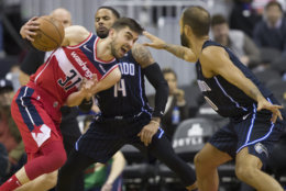 Washington Wizards guard Tomas Satoransky, left, from the Czech Republic, drives against Orlando Magic guards D.J. Augustin and Evan Fournier, right, from France, during the first half of an NBA basketball game Wednesday, March 13, 2019, in Washington. (AP Photo/Alex Brandon)