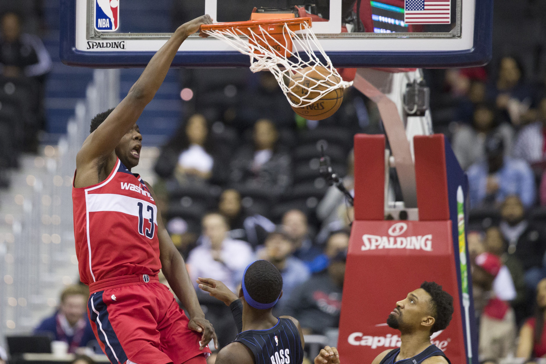 Washington Wizards center Thomas Bryant (13) dunks in front of Orlando Magic guard Terrence Ross, left, and center Khem Birch during the first half of an NBA basketball game Wednesday, March 13, 2019, in Washington. (AP Photo/Alex Brandon)