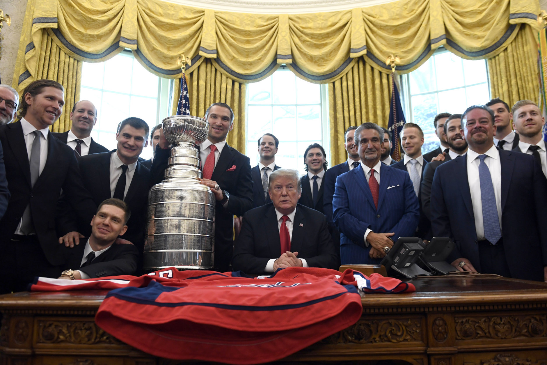 President Donald Trump, center, poses for a photo as he hosts the 2018 Stanley Cup Champion Washington Capitals hockey team in the Oval Office of the White House in Washington, Monday, March 25, 2019. (AP Photo/Susan Walsh)