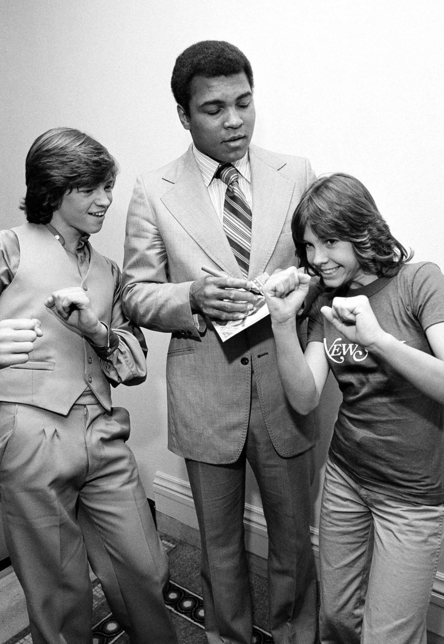 Television actress Christy McNichol shows her brother Jimmy and heavyweight champ Muhammad Ali her pugilistic style as Ali signs a copy of the 45 RPM record that the McNichols released. The action took place at New York?s Plaza Hotel, May 5, 1978, where both the McNichols and Ali are staying. (AP Photo/G. Paul Burnett)