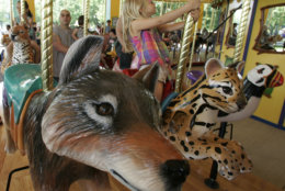 Paige McCoy rides a leopard cub on Brookfield Zoo's new carousel Saturday May, 27, 2006 in Brookfield, Ill. The new attraction is the largest non-restored hand carved wooden carousel in the country and features 72 animals representing a variety of mammals, birds, insects, reptiles and amphibians. (AP Photo/M. Spencer Green)