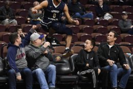 George Washington's Justin Mazzulla (0) jumps between fans back onto the court after running out of bounds on a play during the first half of an NCAA college basketball game against South Carolina, Sunday, Nov. 18, 2018, in Uncasville, Conn. (AP Photo/Jessica Hill)