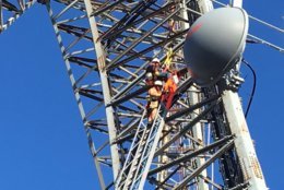Zoom-in picture of a worker attempting to climb down from a radio tower in D.C. (Courtesy DC Fire and EMS/Twitter)