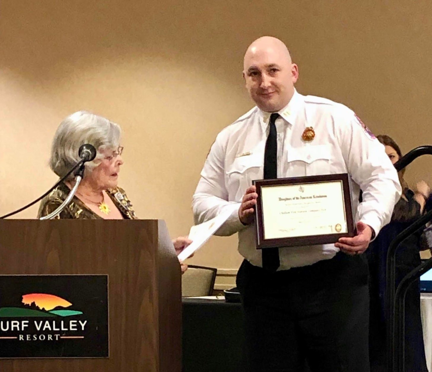Barbara May, Historic Preservation Awards Chairman for the Daughters of the American Revolution, presents Captain Ushinski with the Historic Preservation Award. (Courtesy Prince George's County Fire and EMS)