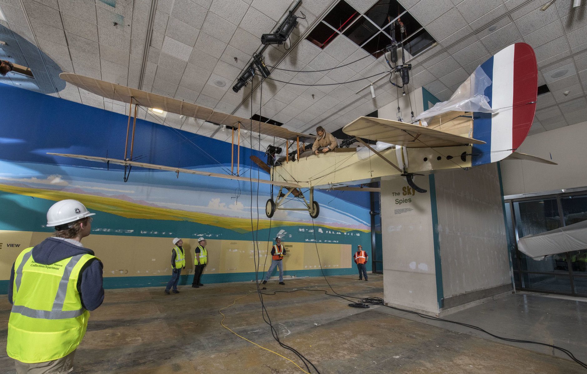 National Air and Space Museum staff and contractors from iWeiss; Century Aviation; and Crozier Fine Arts, work to lower the De Havilland DH-4 aircraft in the closed Looking at Earth gallery of the National Air and Space museum in Washington, DC, February 12, 2019. (Smithsonian  photo by Jim Preston)  Material is subject to Smithsonian Terms of Use. Should you wish to use National Air and Space material in any medium, please submit an Application for Permission to Reproduce NASM Material, available at:  https://airandspace.si.edu/permissions