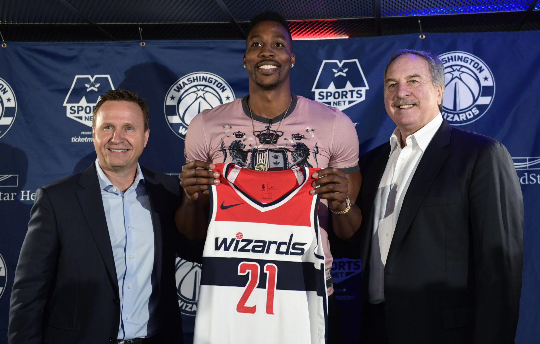 Washington Wizards recently acquired center Dwight Howard, center, flanked by Wizards coach Scott Brooks, left, and Wizards President Ernie Grunfeld, right, pose for a photo during a news conference in Washington, Monday, July 23, 2018. Howard, an eight-time All-Star, averaged 16.6 points per game and 12.5 rebounds last season with the Charlotte Hornets. (AP Photo/Susan Walsh)