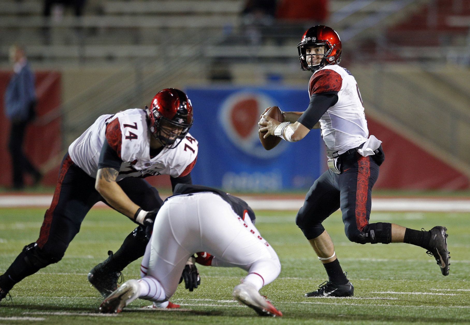 San Diego State quarterback Ryan Agnew, right, throws as offensive lineman Tyler Roemer (74) contains a New Mexico defender during the first half of an NCAA college football game in Albuquerque, N.M., Saturday, Nov. 3, 2018. (AP Photo/Andres Leighton)