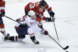 Washington Capitals right wing T.J. Oshie (77) and Florida Panthers defenseman Mark Pysyk (13) go for the puck during the third period of an NHL hockey game, Monday, April 1, 2019, in Sunrise, Fla. (AP Photo/Lynne Sladky)
