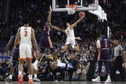 Virginia guard Kihei Clark (0) drives to the basket past Auburn center Austin Wiley during the first half in the semifinals of the Final Four NCAA college basketball tournament, Saturday, April 6, 2019, in Minneapolis. (AP Photo/David J. Phillip)
