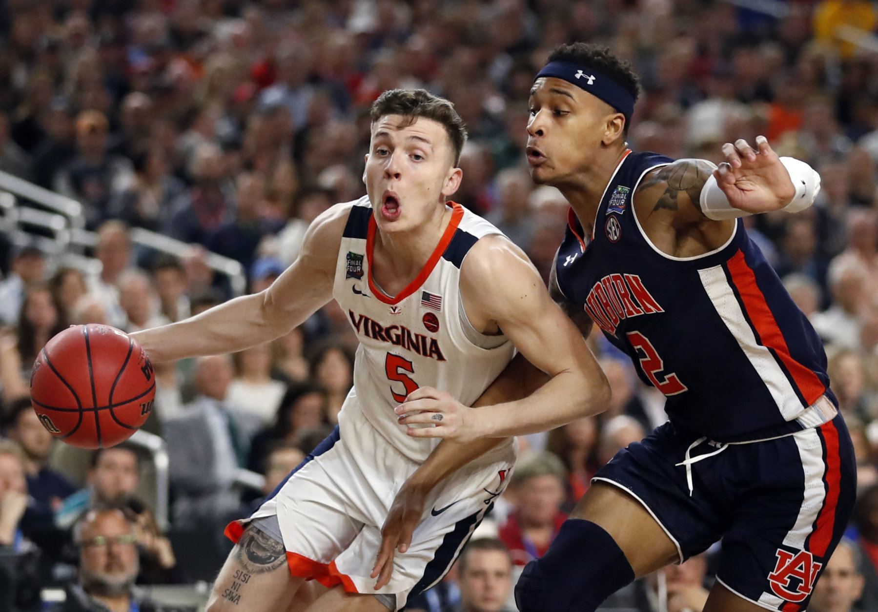 Virginia's Kyle Guy (5) drives against Auburn's Bryce Brown (2) during the first half in the semifinals of the Final Four NCAA college basketball tournament, Saturday, April 6, 2019, in Minneapolis. (AP Photo/Jeff Roberson)