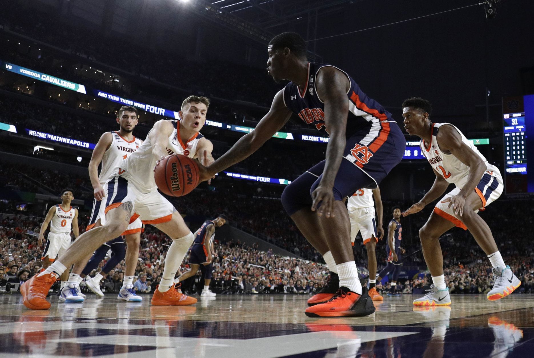 Virginia guard Kyle Guy, left, fights for a loose ball with Auburn forward Danjel Purifoy during the second half in the semifinals of the Final Four NCAA college basketball tournament, Saturday, April 6, 2019, in Minneapolis. (AP Photo/Jeff Roberson)