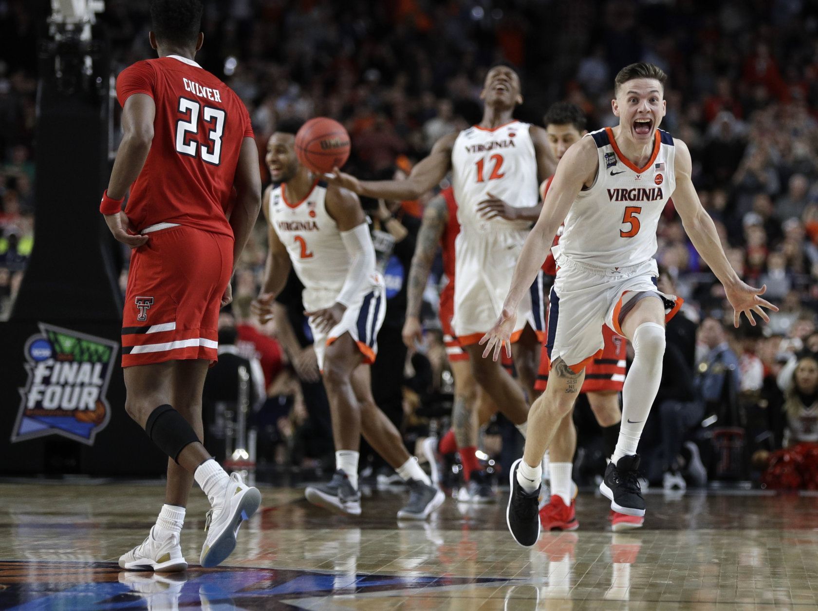 Virginia guard Kyle Guy (5) celebrates in front of Texas Tech guard Jarrett Culver (23) at the end of the championship game in the Final Four NCAA college basketball tournament, Monday, April 8, 2019, in Minneapolis. Virginia won 85-77 in overtime. (AP Photo/David J. Phillip)