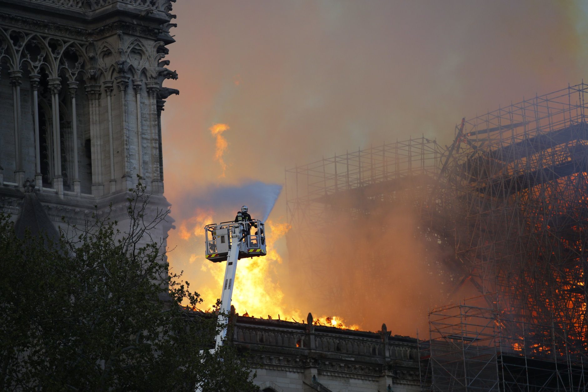 A firefighter uses a hose as Notre Dame cathedral burns in Paris, Monday, April 15, 2019. A catastrophic fire engulfed the upper reaches of Paris' soaring Notre Dame Cathedral as it was undergoing renovations Monday, threatening one of the greatest architectural treasures of the Western world as tourists and Parisians looked on aghast from the streets below. (AP Photo/Francois Mori)