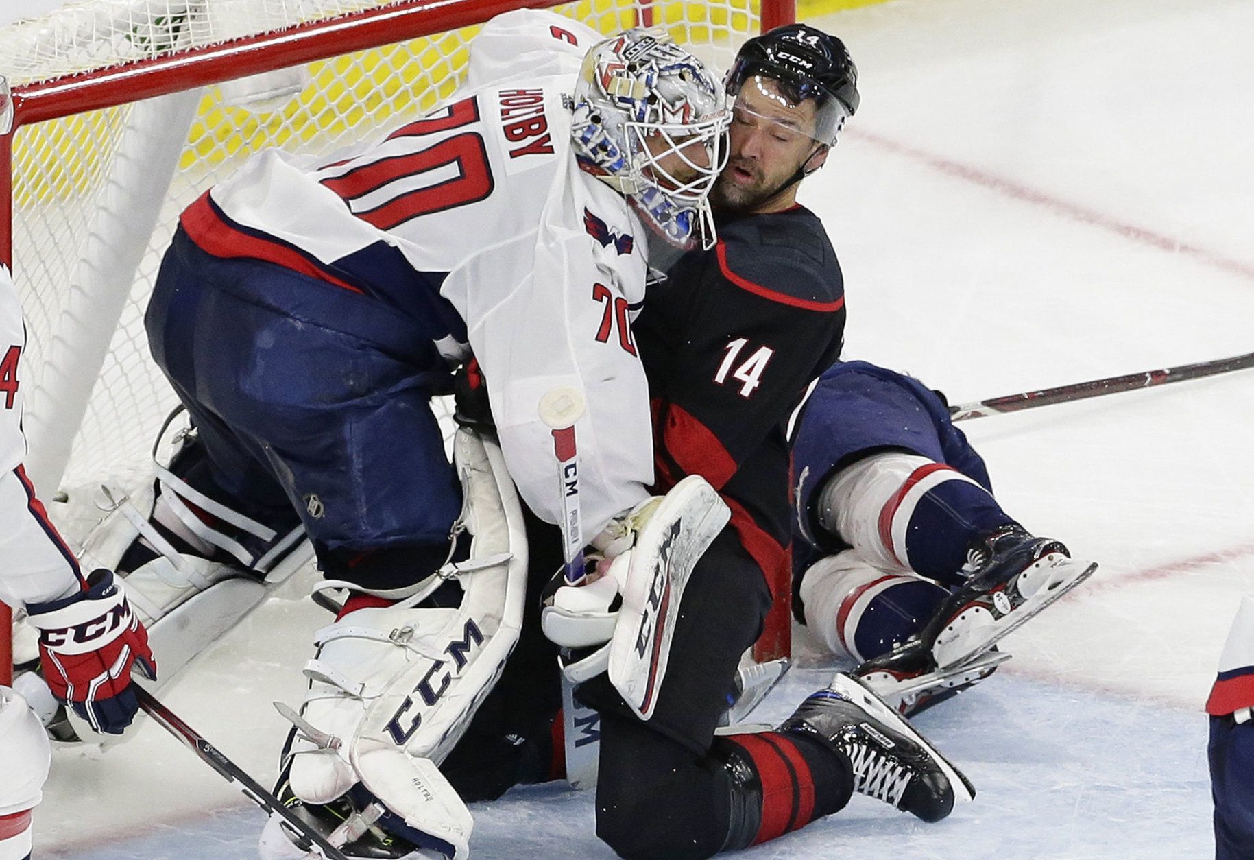 Carolina Hurricanes' Justin Williams (14) collides with Washington Capitals goalie Braden Holtby (70) during the second period of Game 6 of an NHL hockey first-round playoff series in Raleigh, N.C., Monday, April 22, 2019. (AP Photo/Gerry Broome)