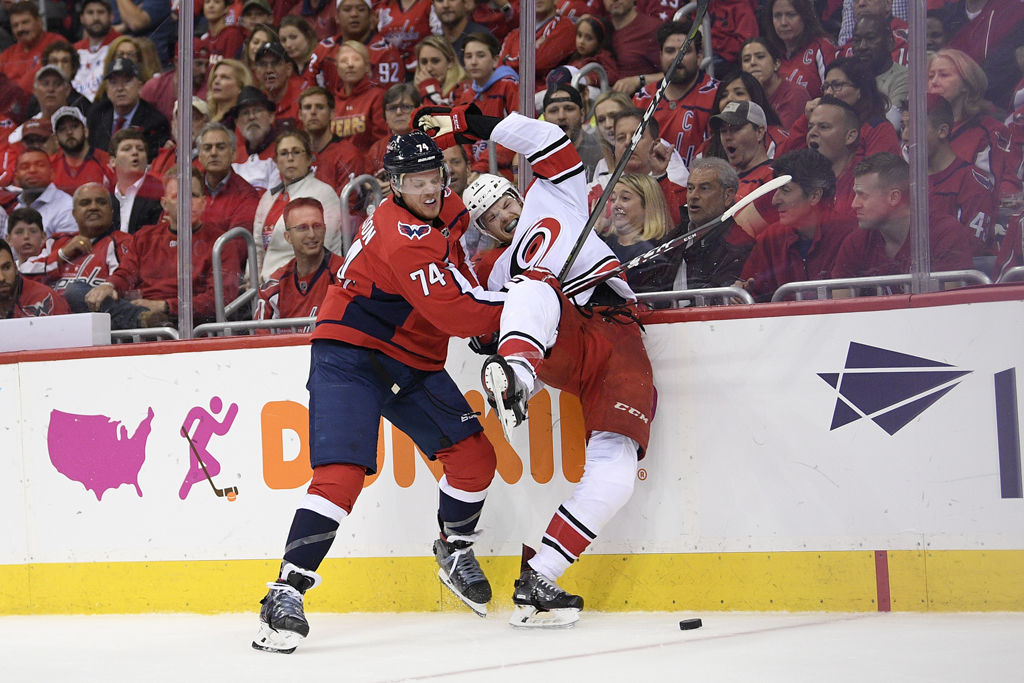 Washington Capitals defenseman John Carlson (74) checks Carolina Hurricanes left wing Warren Foegele, right, into the boards during the first period of Game 7 of an NHL hockey first-round playoff series, Wednesday, April 24, 2019, in Washington. (AP Photo/Nick Wass)