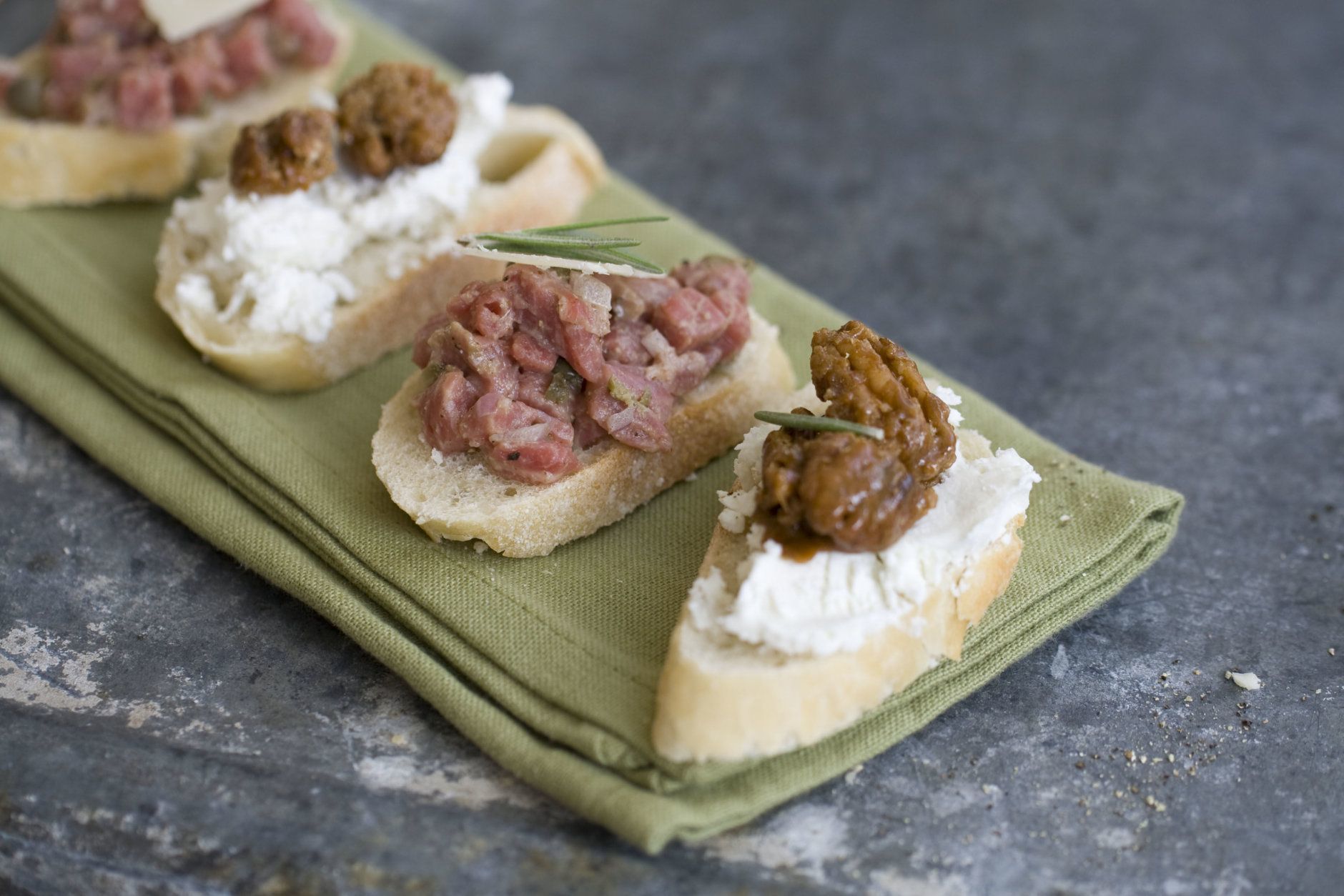 This Oct. 21, 2013 photo shows crostini topped with goat cheese and candied nuts or steak tartare in Concord, N.H. For Thanksgiving, no-cook dishes can be sprinkled throughout the meal. (AP Photo/Matthew Mead)