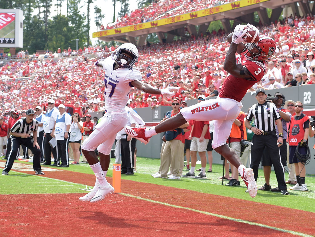 RALEIGH, NC - SEPTEMBER 01:  Kelvin Harmon #3 of the North Carolina State Wolfpack is called out of bounds as he makes a leaping catch against Taurus Carroll #27 of the James Madison Dukes during their game at Carter-Finley Stadium on September 1, 2018 in Raleigh, North Carolina.  (Photo by Grant Halverson/Getty Images)