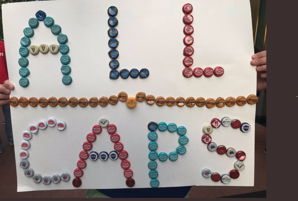Fann shows All Caps signs made of bottle caps during Game 7, on Wednesday, April 24, 2019. (WTOP/Michelle Basch)
