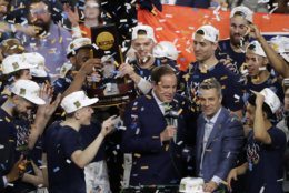 Virginia head coach Tony Bennett, right, celebrates with his team after the championship game against Texas Tech in the Final Four NCAA college basketball tournament, Monday, April 8, 2019, in Minneapolis. Virginia won 85-77 in overtime.(AP Photo/Matt York)