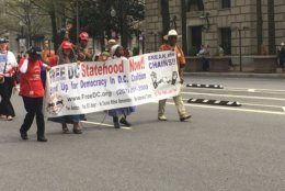 Parade participants hold a banner for statehood during D.C.'s Emancipation Day Parade on Saturday, April 13, 2019. (WTOP/Rick Massimo)