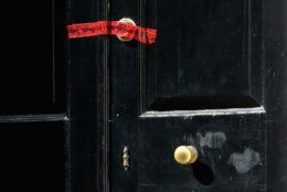 WASHINGTON, DC - MAY 19:  Red crime scene tape seals the front door of a house on the 3200 block of Woodland Drive NW May 19, 2015 in Washington, DC. Firefighters discovered the bodies of Savvas Savopoulos, 46, his wife Amy, 47, their 10-year-old son Philip, and the housekeeper, Veralicia Figueroa, 57, last Thursday afternoon when they responded to a blaze at the house. Two Savopoulos daughters were away in boarding school at the time. Investigators have ruled the deaths homicides and say they could continue to collect evidence at the house for another week.  (Photo by Chip Somodevilla/Getty Images)