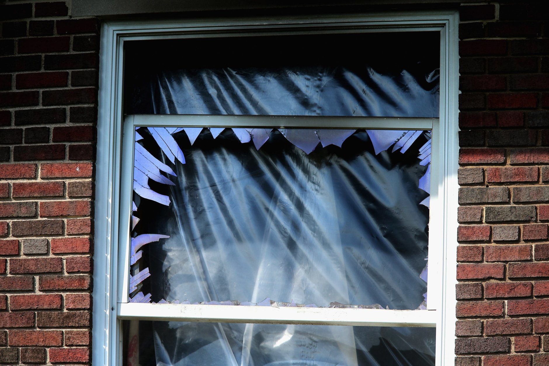 WASHINGTON, DC - MAY 19:  Smashed windows and heavy fire damage scar a house on the 3200 block of Woodland Drive NW May 19, 2015 in Washington, DC. Firefighters discovered the bodies of Savvas Savopoulos, 46, his wife Amy, 47, their 10-year-old son Philip, and the housekeeper, Veralicia Figueroa, 57, last Thursday afternoon when they responded to a blaze at the house. Two Savopoulos daughters were away in boarding school at the time. Investigators have ruled the deaths homicides and say they could continue to collect evidence at the house for another week.  (Photo by Chip Somodevilla/Getty Images)