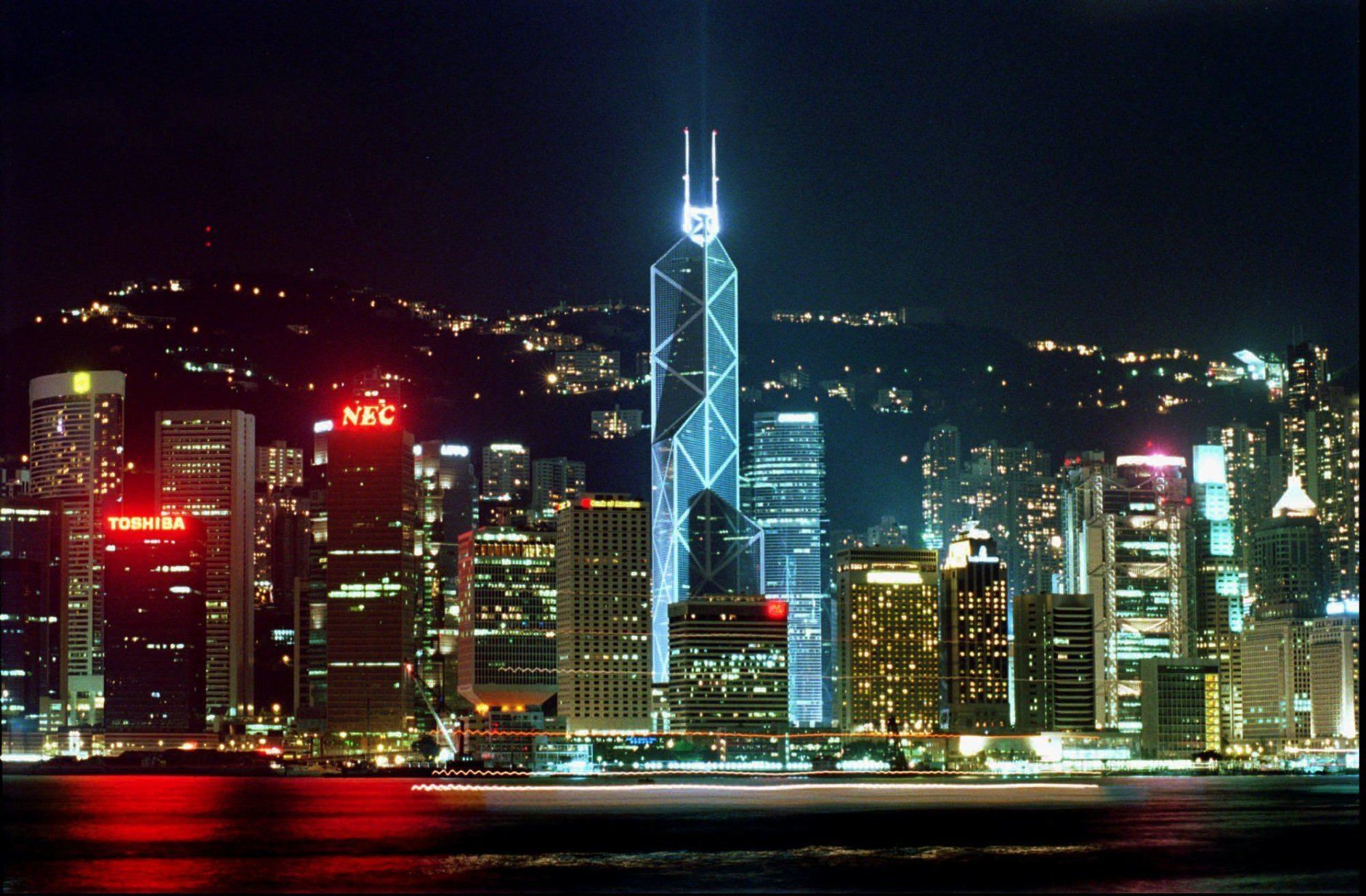 HONG KONG 1997 PHOTO PACKAGE GENERAL VIEW -Third of 8- The Victoria Harbor skyline is illuminated by commercial buildings along the waterfront of Hong Kong Island. The Bank of China building, center, designed by Chinese-American architect I.M. Pei to look like an angular bamboo shoot, was completed in 1989. It is one of Hong Kong's most recognized landmarks and a symbol of China's strong economic stake in the territory. Picture taken on Saturday, Sept. 7, 1996. (AP Photo/Anat Givon)