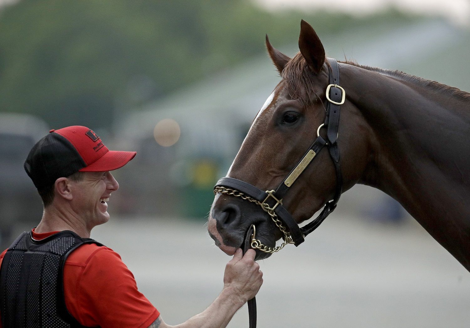 Exercise rider Brian Duggan holds Kentucky Derby hopeful Code of Honor for his bath after a workout at Churchill Downs Tuesday, April 30, 2019, in Louisville, Ky. The 145th running of the Kentucky Derby is scheduled for Saturday, May 4. (AP Photo/Charlie Riedel)