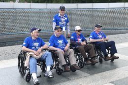 Some of the veterans from the Midwest Honor Flight pose at the WWII Memorial.  Int total, 82 veterans made the trip. (WTOP/Michelle Basch)