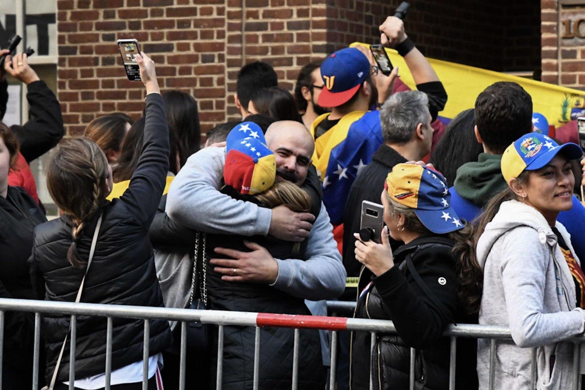 Two Venezuelans embrace in celebration as a months-long occupation of the embassy by pro-Maduro activists seemed to be coming to an end. Arrests had not occurred as of Wednesday morning, though notice had been served that the four activists who remained within were in violation of D.C. and federal law. (WTOP/Alejandro Alvarez)