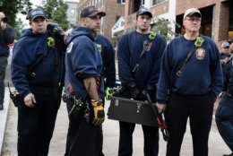 The D.C. fire department arrived with bolt cutters to remove chains and a bike lock which activists had sealed the Venezuelan Embassy's front entrance with. (WTOP/Alejandro Alvarez)