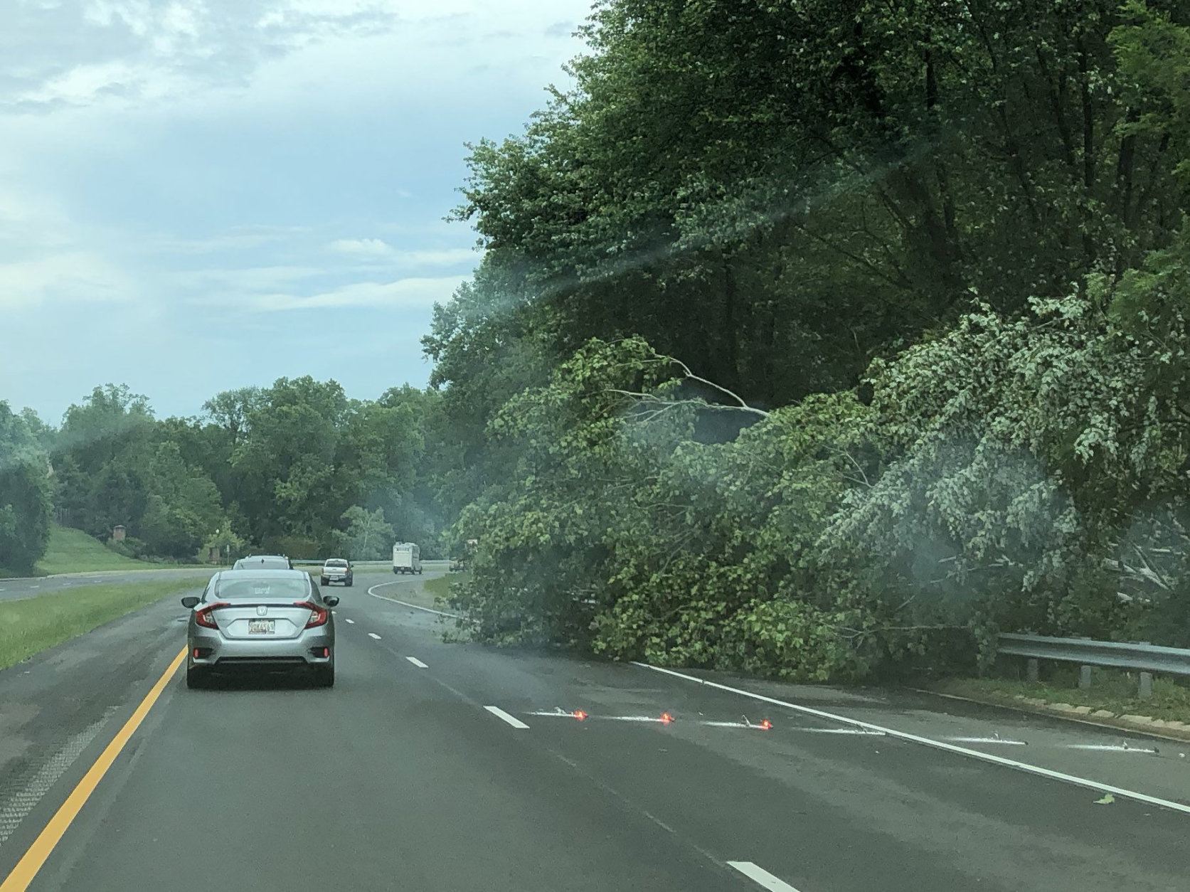 The storm may be over, but a downed tree blocks a lane on the Midcounty Highway in Gaithersburg, Maryland. (WTOP/Mike Murillo)