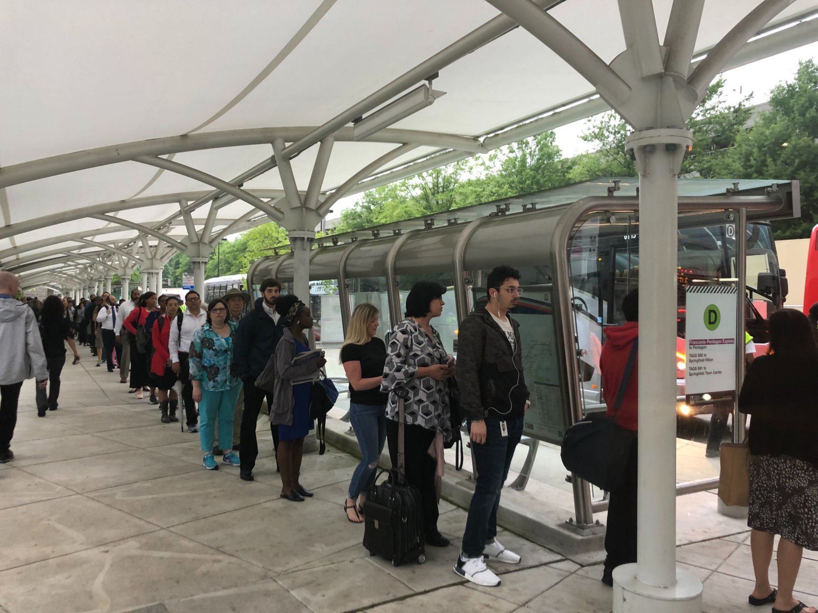 Commuters line up for a Metro shuttle bus outside the Franconia-Springfield station. (WTOP/Melissa Howell)