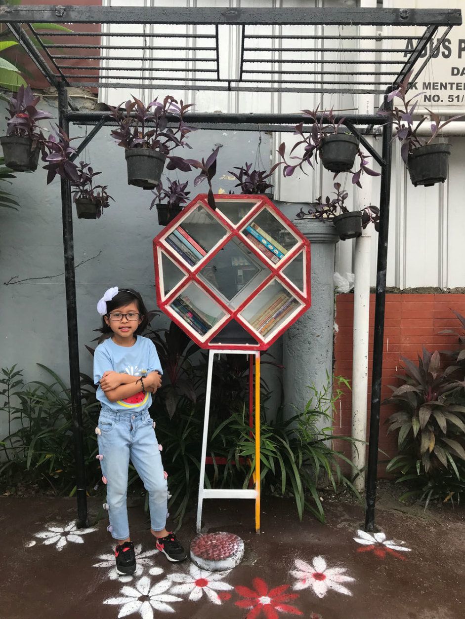 Lana Basri standing next to her Free Little Library in West Java, Indonesia. (Courtesy Basri family)