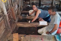 Catherine Morrison, the current owner of the Bayly propter, working with an archaeologist to excavate artifacts beneath the floorboards. (Courtesy Dorchester County)