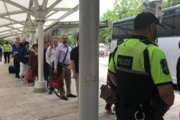 Metro riders wait in line to catch shuttles now that six stations are closed for the summer. (WTOP/Melissa Howell)