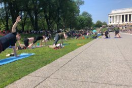 Despite sweltering temperatures, thousands brought their yoga mats to the National Mall on Sunday, May 19, 2019. (WTOP/Keara Dowd)