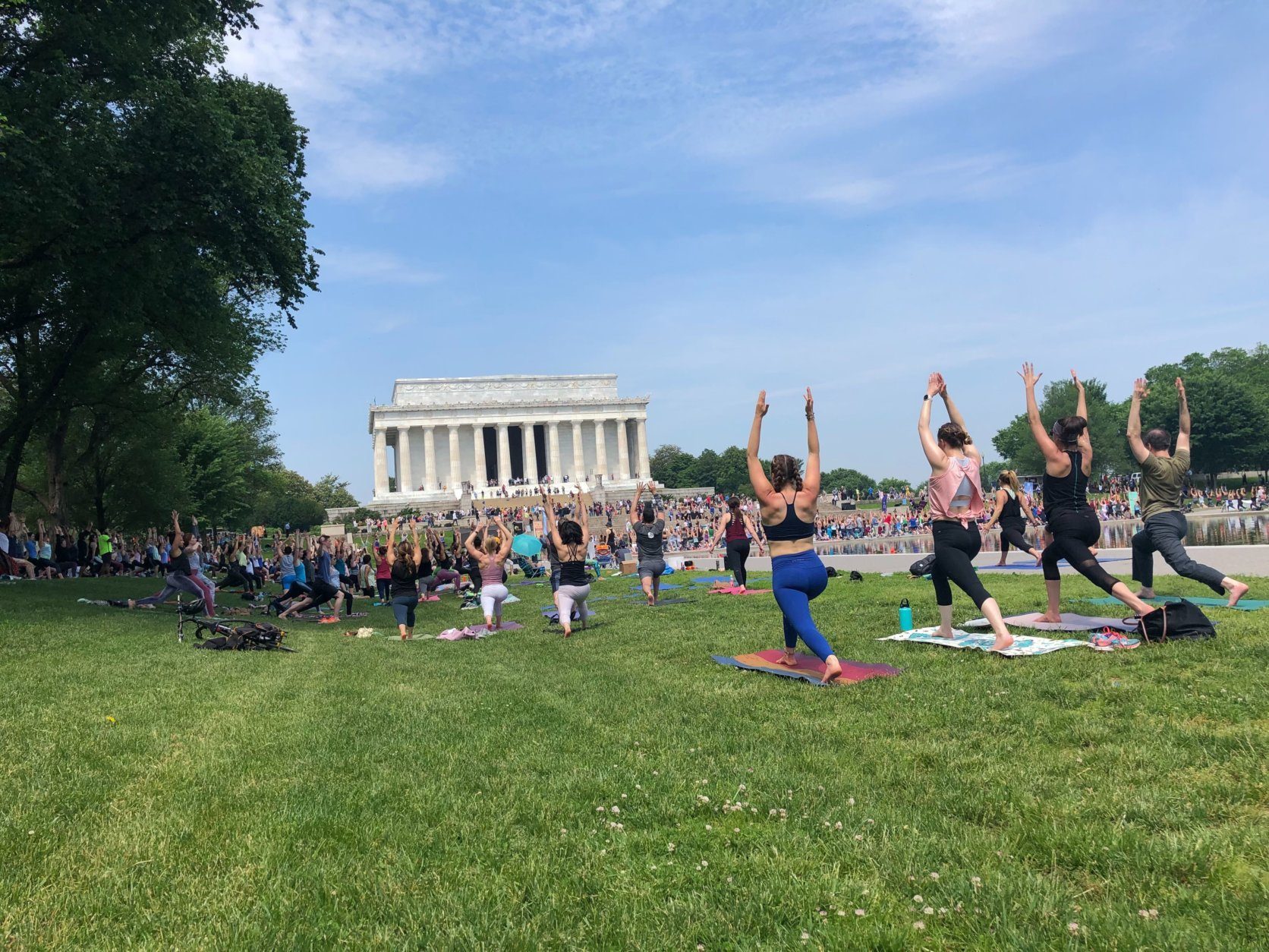  Temperatures were hovering in the upper 80s, near 90 on Sunday, but that didn't stop these yogis from holding a session on the National Mall. (WTOP/Keara Dowd)