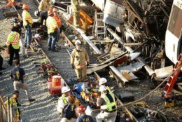 Investigators and officials look over the collision scene of two Metro transit trains in Northeast Washington, Tuesday, June 23, 2009. (AP Photo/Gerald Herbert)