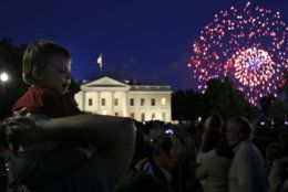 Louis Celli of Montgomery Village, Md., carries his 18-month-old grandson Jayden on his shoulders to watch the fireworks in front of the White House marking Independence Day celebrations in Washington, Friday, July 4, 2014. (AP Photo/Charles Dharapak)
