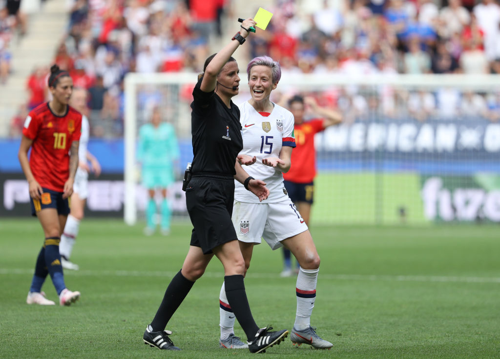 REIMS, FRANCE - JUNE 24: Megan Rapinoe of the USA reacts to referee Katalin Kulcsar as she shows a yellow card during the 2019 FIFA Women's World Cup France Round Of 16 match between Spain and USA at Stade Auguste Delaune on June 24, 2019 in Reims, France. (Photo by Robert Cianflone/Getty Images)