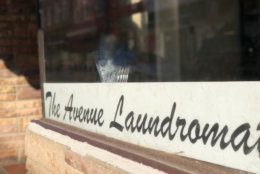 Another sign that this is a tight-knit community is a literal sign in the business's window: Reading "The Avenue Laudromat," it was made for Small by a customer. (WTOP/Kate Ryan)